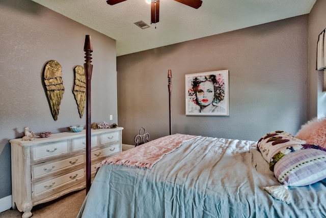 carpeted bedroom featuring ceiling fan and a textured ceiling