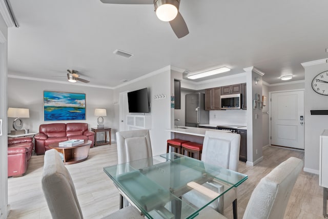 dining area featuring crown molding, ceiling fan, and light hardwood / wood-style floors