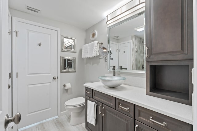 bathroom with hardwood / wood-style floors, vanity, and toilet