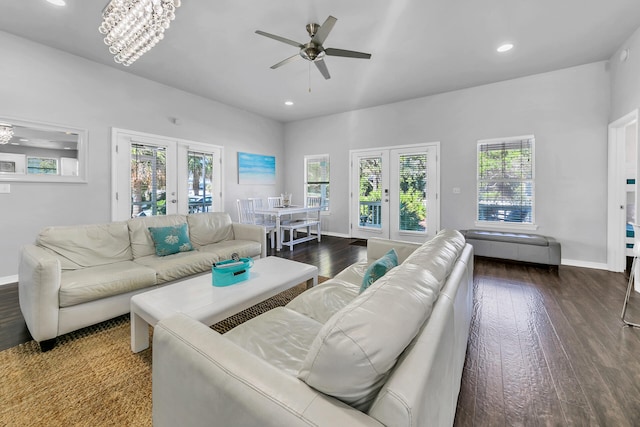 living room with french doors, dark wood-type flooring, and ceiling fan with notable chandelier