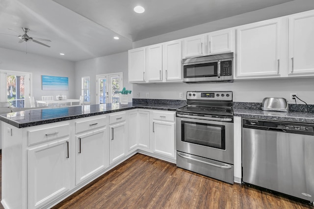 kitchen featuring kitchen peninsula, white cabinetry, dark hardwood / wood-style flooring, and stainless steel appliances