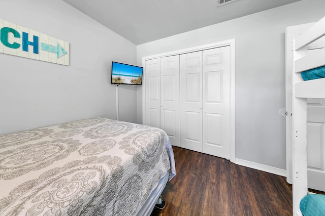 bedroom with lofted ceiling, a closet, and dark wood-type flooring