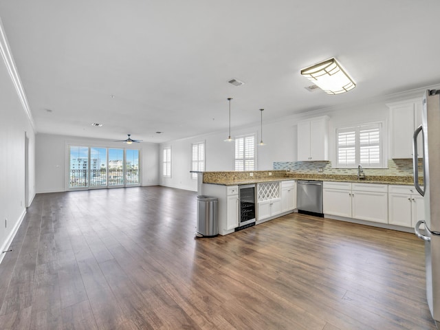 kitchen with kitchen peninsula, white cabinetry, beverage cooler, and stainless steel appliances