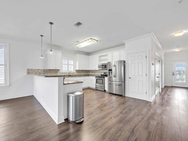 kitchen featuring white cabinets, hanging light fixtures, dark hardwood / wood-style floors, kitchen peninsula, and stainless steel appliances