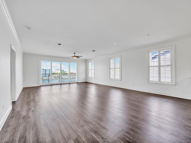 empty room with ceiling fan, ornamental molding, and dark wood-type flooring