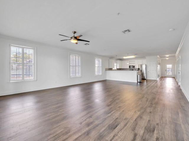 unfurnished living room with crown molding, ceiling fan, and dark hardwood / wood-style floors