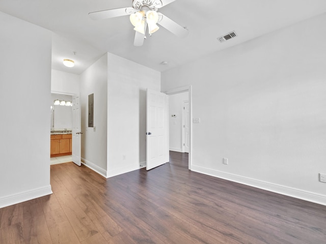 spare room with electric panel, ceiling fan, and dark hardwood / wood-style flooring