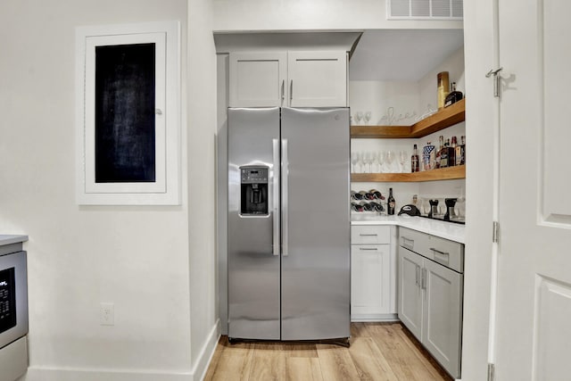 kitchen featuring gray cabinets, light hardwood / wood-style flooring, and stainless steel refrigerator with ice dispenser