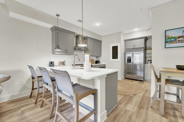 179 S County Highway 393 # 324, Santa Rosa Beach, FL 32459 - kitchen with stainless steel fridge with ice dispenser, wall chimney range hood, gray cabinets, a peninsula, and light countertops