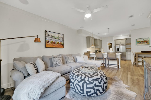 living room featuring ceiling fan and light hardwood / wood-style floors