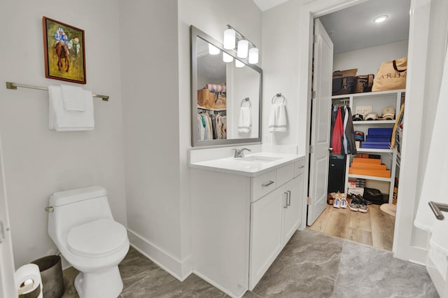 bathroom featuring wood-type flooring, vanity, and toilet