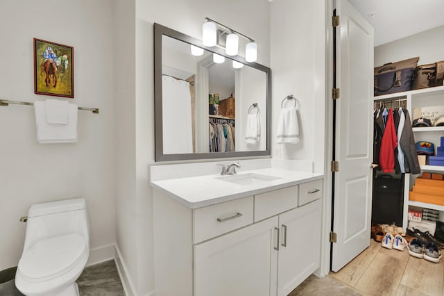 bathroom featuring toilet, vanity, and hardwood / wood-style flooring