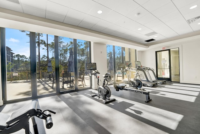 workout area featuring a paneled ceiling and a healthy amount of sunlight