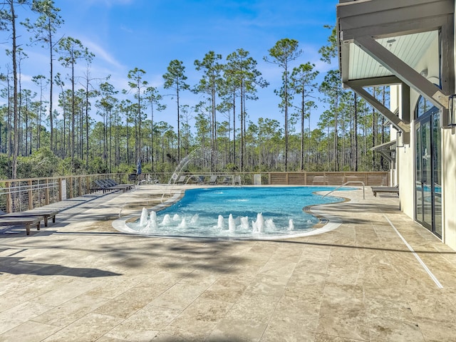 view of swimming pool featuring pool water feature and a patio