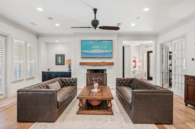 living room featuring ceiling fan, light hardwood / wood-style floors, ornamental molding, and french doors