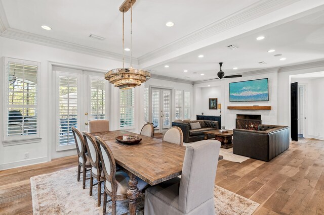 dining room featuring ceiling fan with notable chandelier, light hardwood / wood-style floors, and ornamental molding