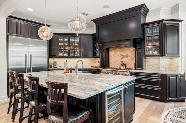 bar with hanging light fixtures, sink, wine cooler, light wood-type flooring, and stainless steel appliances