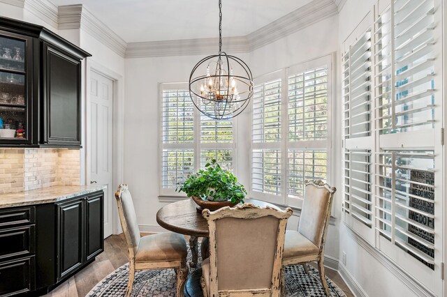 dining area featuring an inviting chandelier, light hardwood / wood-style flooring, plenty of natural light, and crown molding