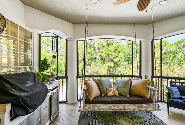 sunroom / solarium featuring plenty of natural light and ceiling fan