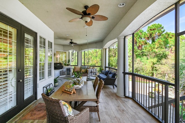 sunroom with french doors, a wealth of natural light, and ceiling fan