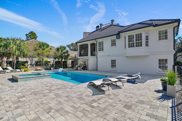 view of swimming pool featuring an in ground hot tub and a patio