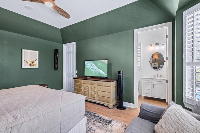 bedroom featuring multiple windows, ceiling fan, light hardwood / wood-style flooring, and ensuite bathroom