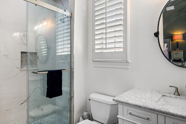 bathroom featuring toilet, an enclosed shower, and vanity