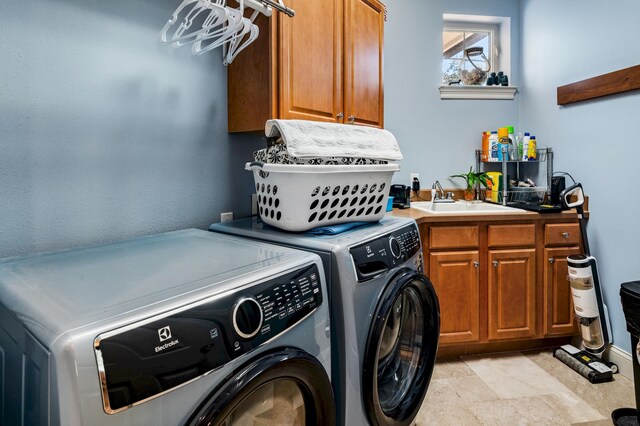 laundry area with cabinets, washing machine and dryer, and sink