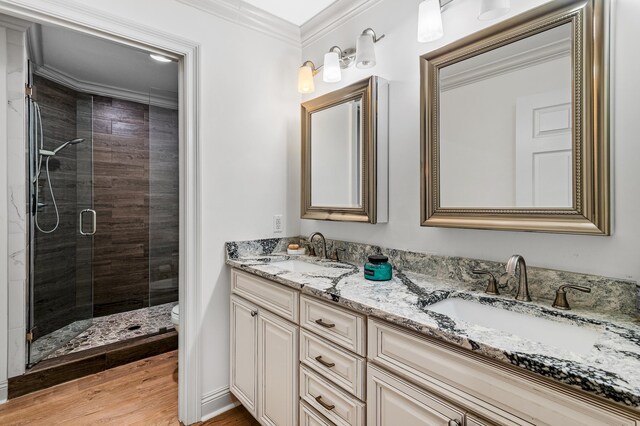 bathroom with vanity, hardwood / wood-style flooring, toilet, ornamental molding, and an enclosed shower