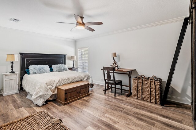 bedroom featuring ceiling fan, crown molding, and light hardwood / wood-style flooring