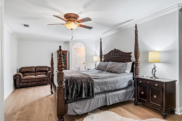 bedroom with ensuite bath, ceiling fan, crown molding, and light hardwood / wood-style floors