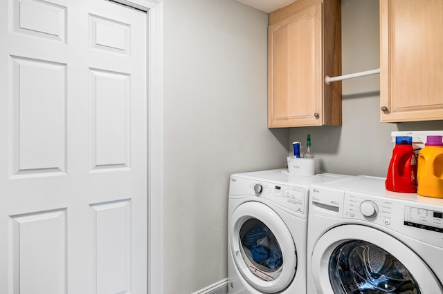 washroom featuring cabinets and washer and clothes dryer