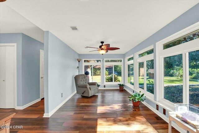 living area with ceiling fan and dark hardwood / wood-style floors