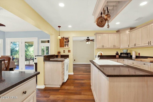 kitchen featuring pendant lighting, a center island, ceiling fan, dark stone countertops, and dark hardwood / wood-style flooring