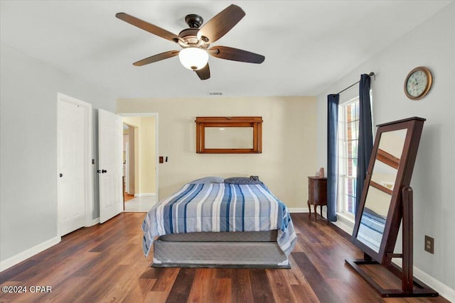 bedroom with ceiling fan, dark hardwood / wood-style flooring, and multiple windows