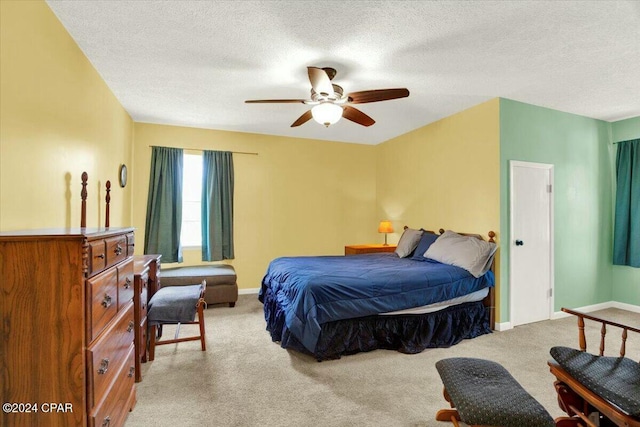 carpeted bedroom featuring a textured ceiling and ceiling fan