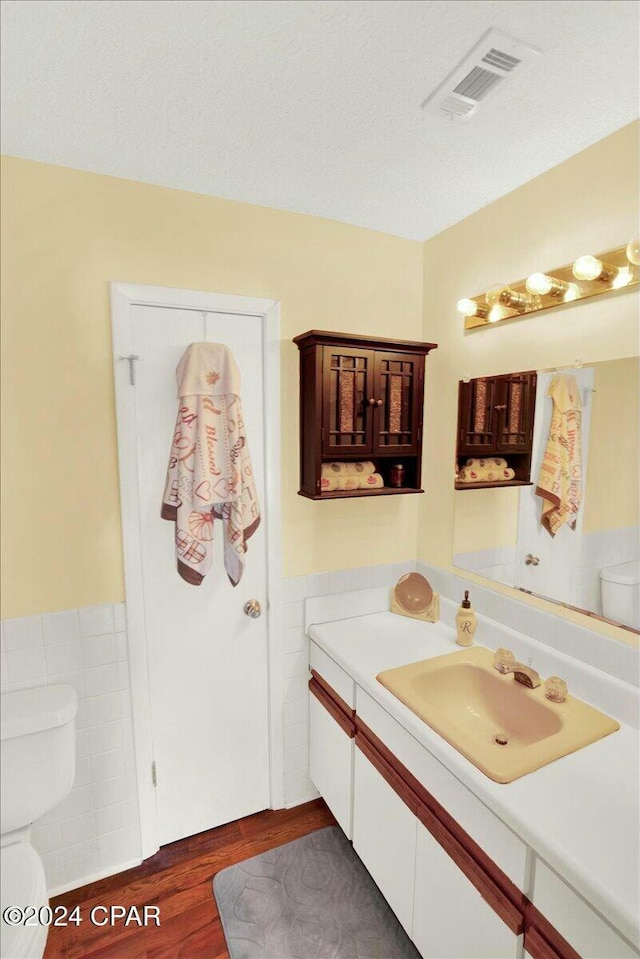 bathroom with vanity, hardwood / wood-style flooring, and toilet