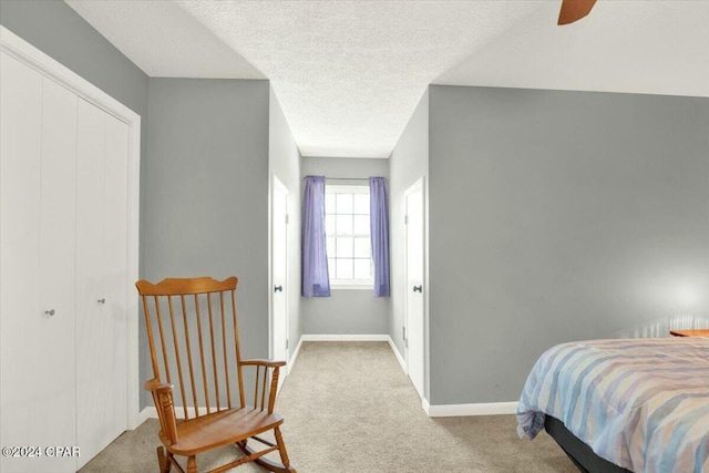 carpeted bedroom featuring a textured ceiling, a closet, and ceiling fan