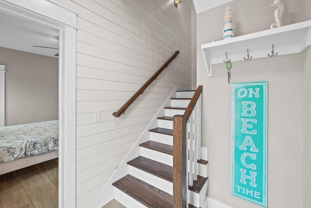 staircase with hardwood / wood-style flooring and wooden walls