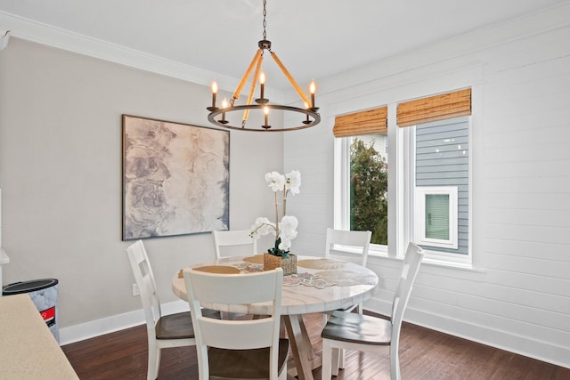 dining room with crown molding, dark wood-type flooring, and a notable chandelier