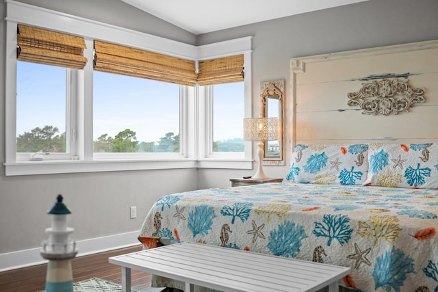 bedroom with hardwood / wood-style flooring, multiple windows, and lofted ceiling