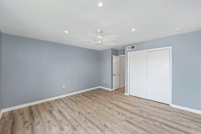 unfurnished bedroom with ceiling fan, a closet, and light wood-type flooring