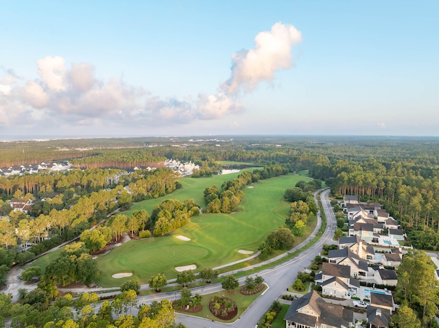 drone / aerial view with view of golf course and a wooded view