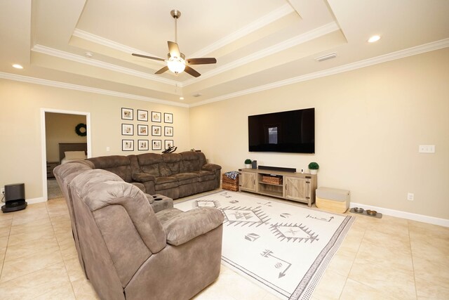 living room featuring ceiling fan, light tile patterned floors, crown molding, and a tray ceiling