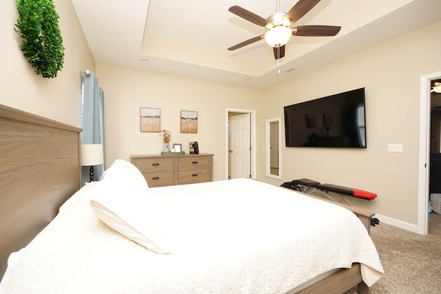 bedroom featuring a tray ceiling, ceiling fan, and carpet floors