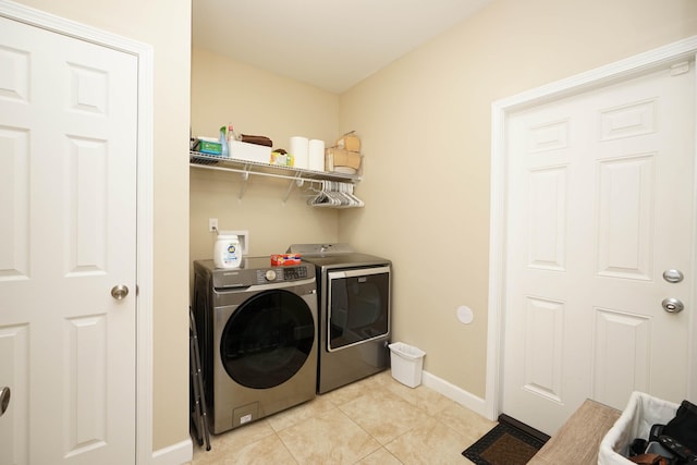 washroom with light tile patterned floors and washing machine and dryer