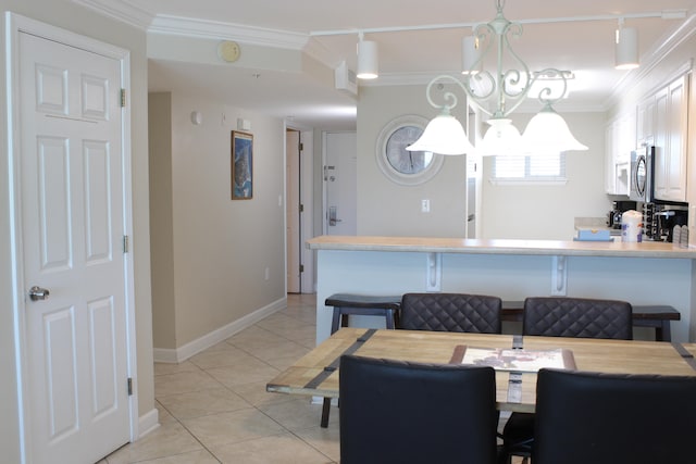 dining space featuring light tile patterned floors, a notable chandelier, and ornamental molding