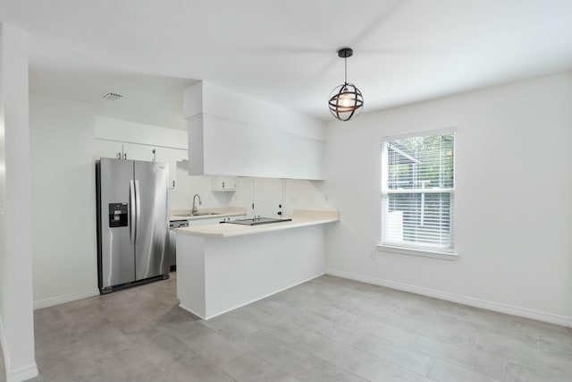 kitchen featuring kitchen peninsula, stainless steel fridge, sink, decorative light fixtures, and white cabinetry