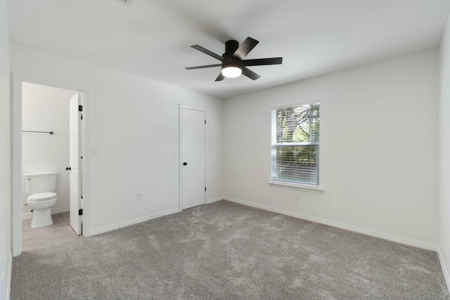 unfurnished bedroom with ensuite bathroom, a closet, ceiling fan, and light colored carpet