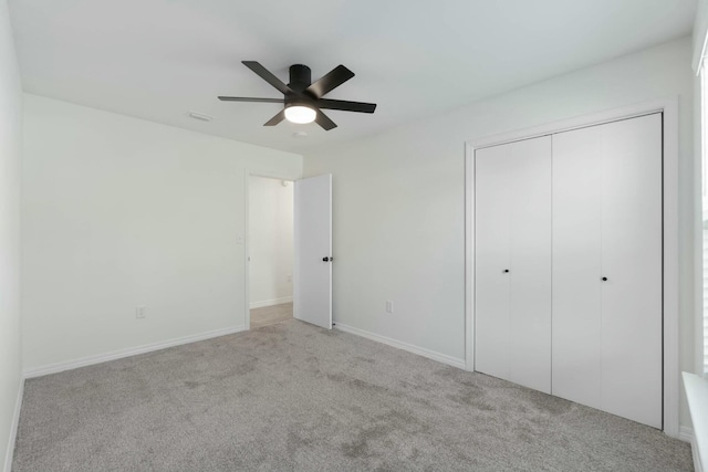 unfurnished bedroom with ceiling fan, a closet, and light colored carpet